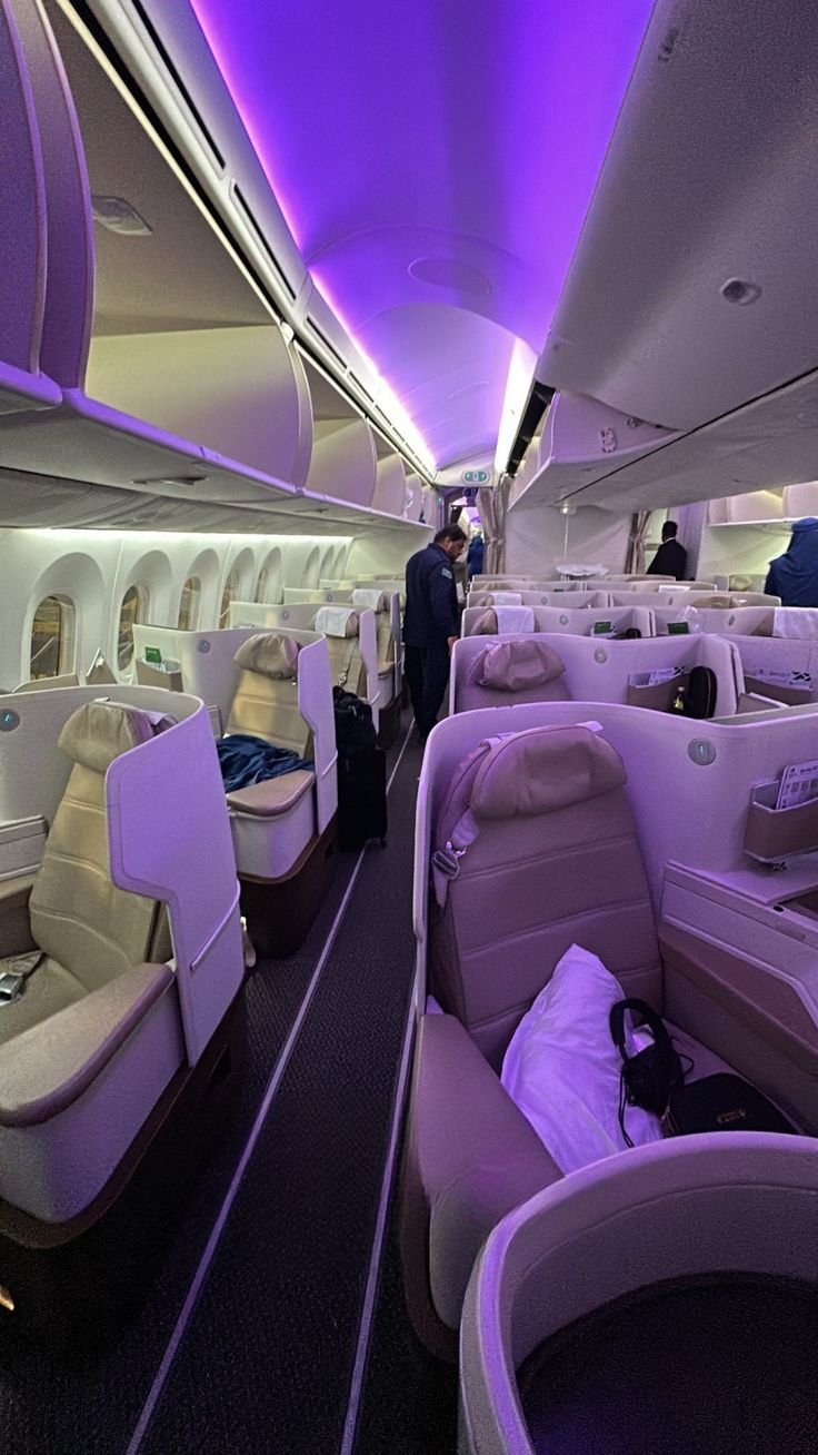 Business class cabin glowing under violet mood lighting